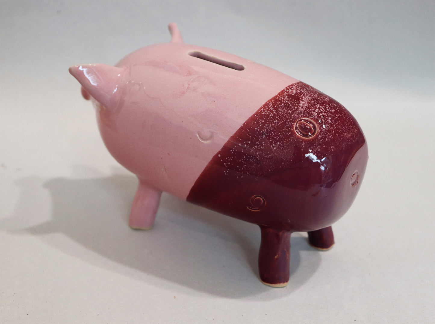 Original Keramik - Sparschwein von Anette Weber, seitliche Ansicht links, Farbe rosa und weinrot, erhältlich bei Galerie Waldbach - What The Artist Made