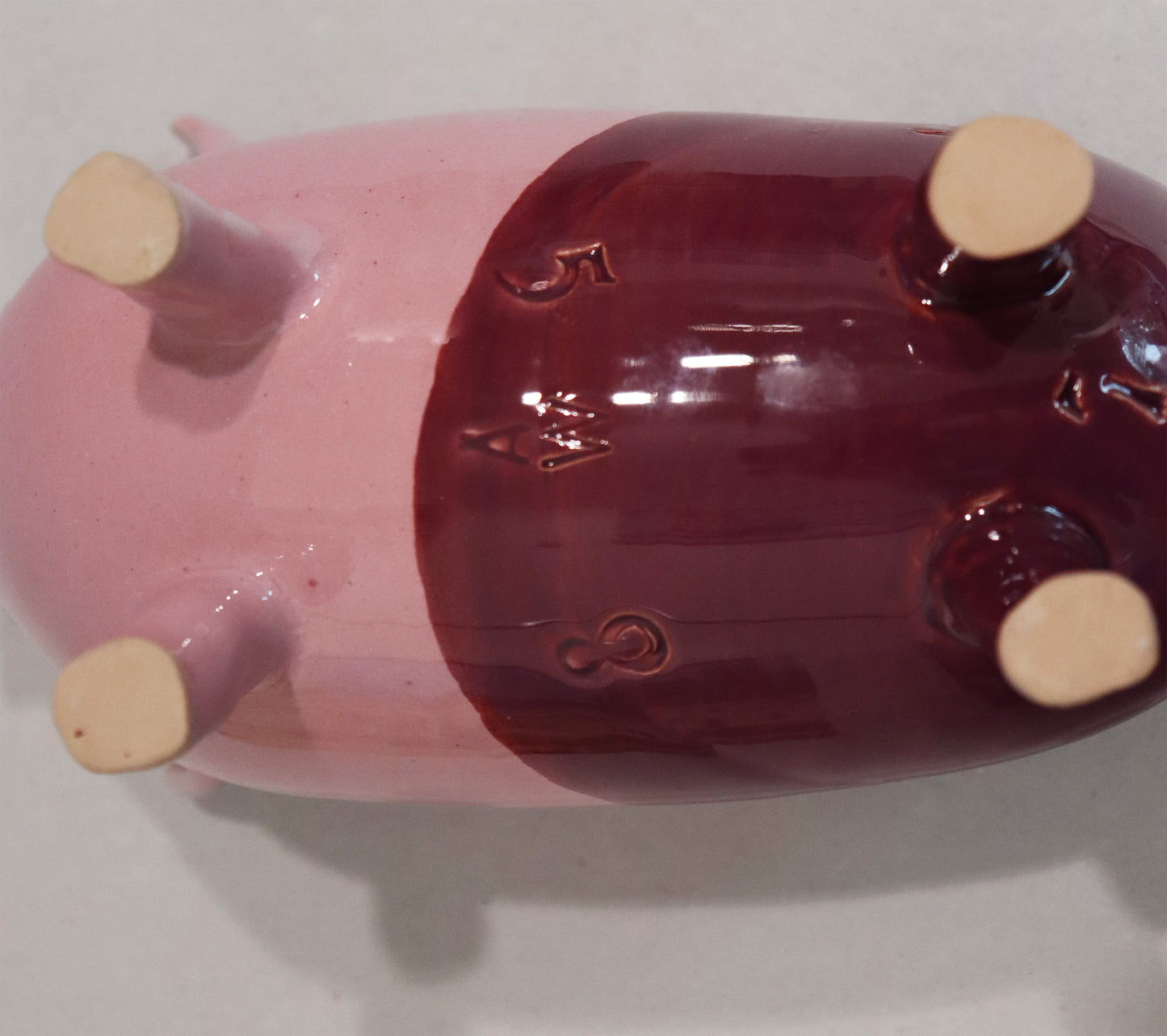 Original Keramik - Sparschwein von Anette Weber, Unterseite mit Signaturstempel "AW", Farbe rosa und weinrot, erhältlich bei Galerie Waldbach - What The Artist Made