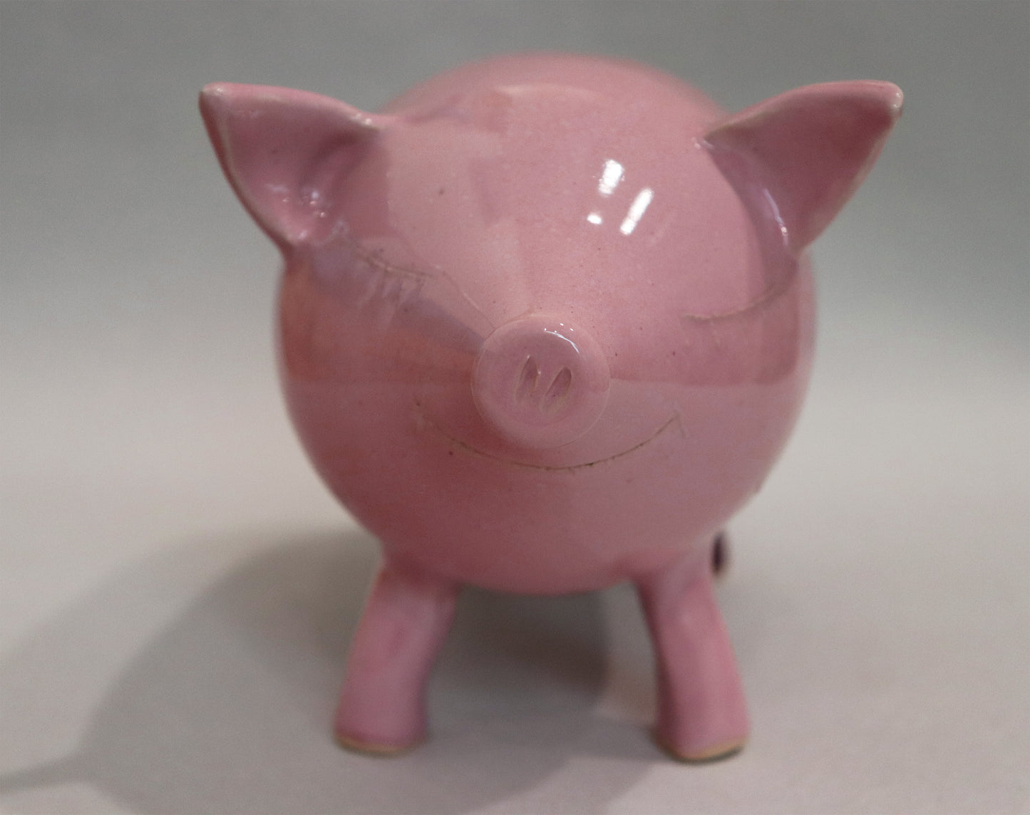 Original Keramik - Sparschwein von Anette Weber, Vorderansicht, Schwein lächelt mit geschlossenen Augen, Farbe rosa und weinrot, erhältlich bei Galerie Waldbach - What The Artist Made