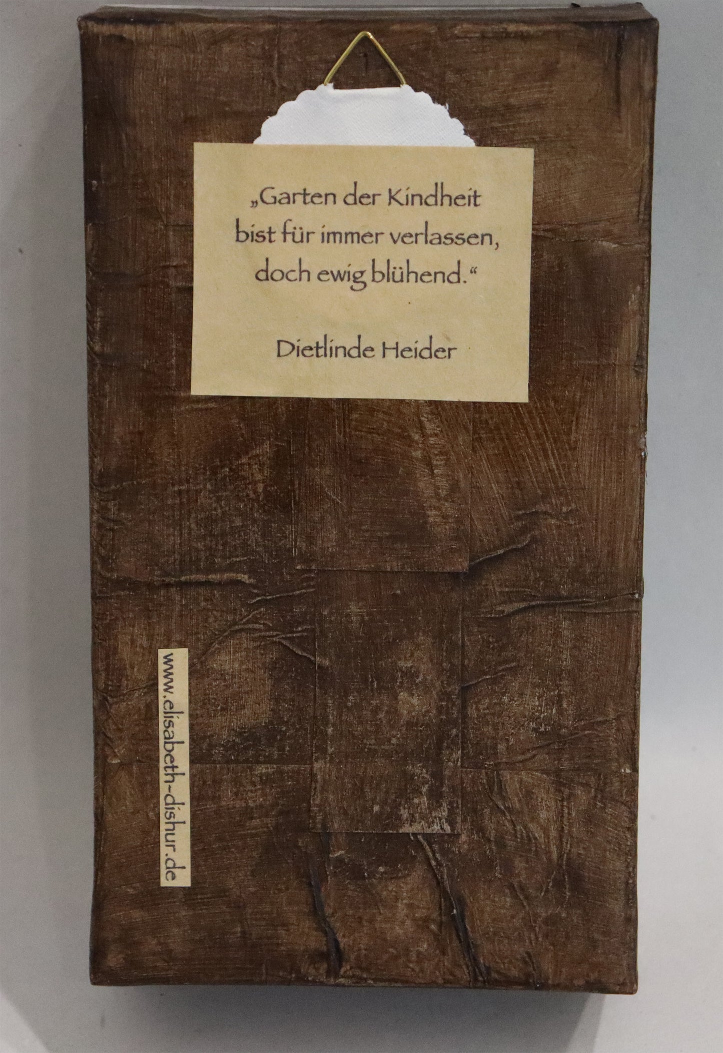 Original Objekt - Assemblage von Elisabeth Dishur, Titel „Minikiste“ – Objektkiste mit Gegenständen. Rückansicht auf Holzkiste - Aufhänger und Text: "Garten der Kindheit bist für immer verlassen, doch ewig blühend." Dietlinde Heider. Objektcollage, erhältlich bei Galerie Waldbach - What The Artist Made
