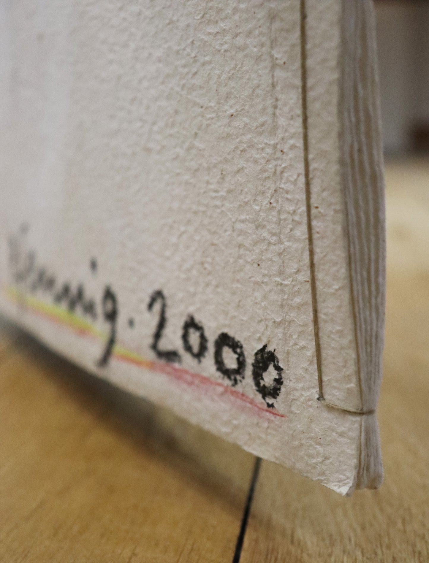 Original Mixed-Media-Objekt von Wolf-Dieter-Pfennig, Titel „Im Atemholen“ – gestaltetes Buch/Heft mit Illustrationen und Textstellen aus Goethes „Westöstlicher Divan - Buch des Sängers“. Detailansicht der Signatur W.-D. Pfennig 2000 und der Bindung der Papiere. Mixed Media auf Papier, signiert, erhältlich bei Galerie Waldbach, What the Artist Made