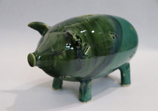 Original Keramik - Sparschwein von Anette Weber, lächelndes Schwein mit Münzeinwurf auf dem Rücken inkl. echtem Glückspfennig, verteilt auf der  Keramik sind Zahlen. Farbe in grün und türkisgrün, erhältlich bei Galerie Waldbach - What The Artist Made