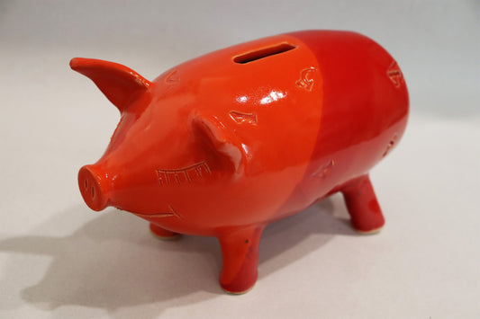Original Keramik - Sparschwein von Anette Weber, lächelndes Schwein mit Münzeinwurf auf dem Rücken inkl. echtem Glückspfennig, verteilt auf der  Keramik sind Zahlen. Farbe in rot und orange, erhältlich bei Galerie Waldbach - What The Artist Made