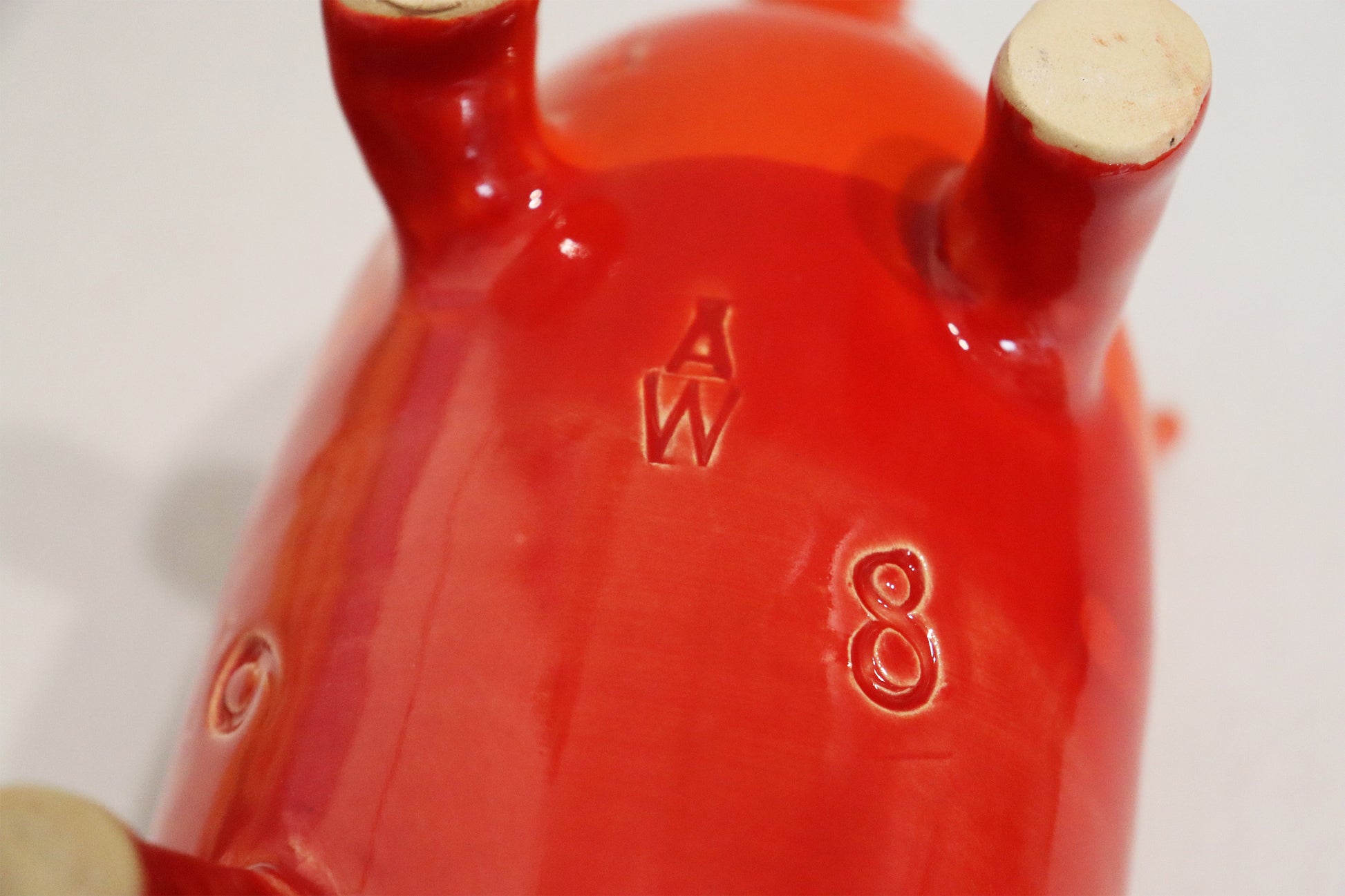 Original Keramik - Sparschwein von Anette Weber, Unterseite mit Signaturstempel "AW",  Farbe rot und orange, erhältlich bei Galerie Waldbach - What The Artist Made