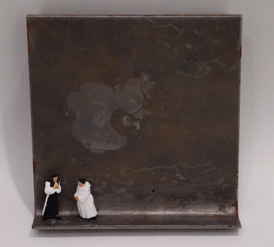 Original Objekt - Assemblage von Katrin Schramm, Titel „Also schweigen wir!“ – Metallwinkel mit Miniatur-Figuren: zwei Priester, einer in schwarzem Habit, einer in weißem Habit, beide stehend, Hände gefaltet. Dahinter das Metall des Winkels mit Struktur, als Hintergrund. - Objektcollage, erhältlich bei Galerie Waldbach - What The Artist Made
