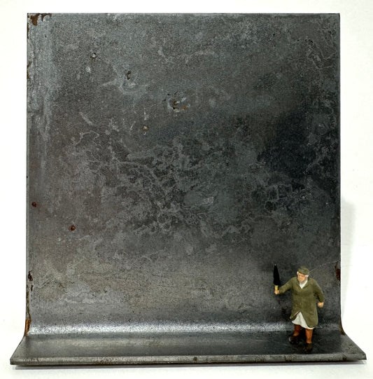 Original Objekt - Assemblage von Katrin Schramm, Titel „Na warte, Bürschchen“ – Metallwinkel mit Miniatur-Figur: ältere Frau rechts auf dem Winkel stehend - sie hält drohend den geschlossenen Regenschirm hoch. Dahinter das Metall des Winkels als Hintergrund. - Objektcollage, erhältlich bei What The Artist Made