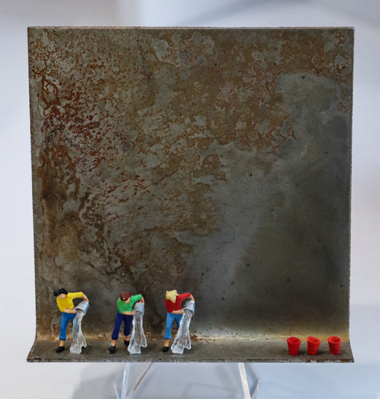 Original Objekt - Assemblage von Katrin Schramm, Titel „Synchron wischen...“ – Metallwinkel mit Miniatur-Figuren:  Drei Frauen stehen am linken Rand bis zur Mitte des Winkels mit Eimern da, die sie schwungvoll auskippen. Aus ihnen ergießt sich Wasser. Am rechten Rand stehen drei rote Eimer. Dahinter das Metall des Winkels mit Struktur, als Hintergrund. - Objektcollage, erhältlich bei Galerie Waldbach - What The Artist Made