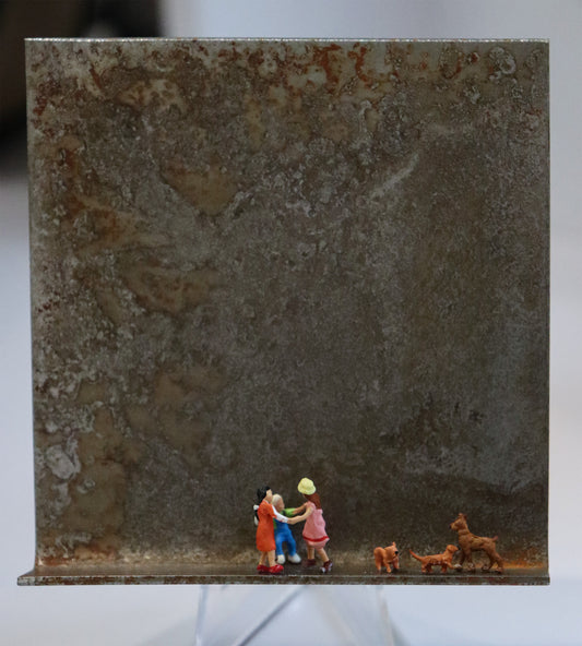 Original Objekt - Assemblage von Katrin Schramm, Titel „Wir wollen nur spielen...“ – Metallwinkel mit Miniatur-Figuren: Drei Kinder tanzen mittig auf dem Rahmen im Ringelreigen, im Kreis. Rechts neben ihnen sind drei braune Hunde, die ihre Formation nachbilden. Dahinter das Metall des Winkels mit Struktur, als Hintergrund. Objektcollage, erhältlich bei Galerie Waldbach - What The Artist Made