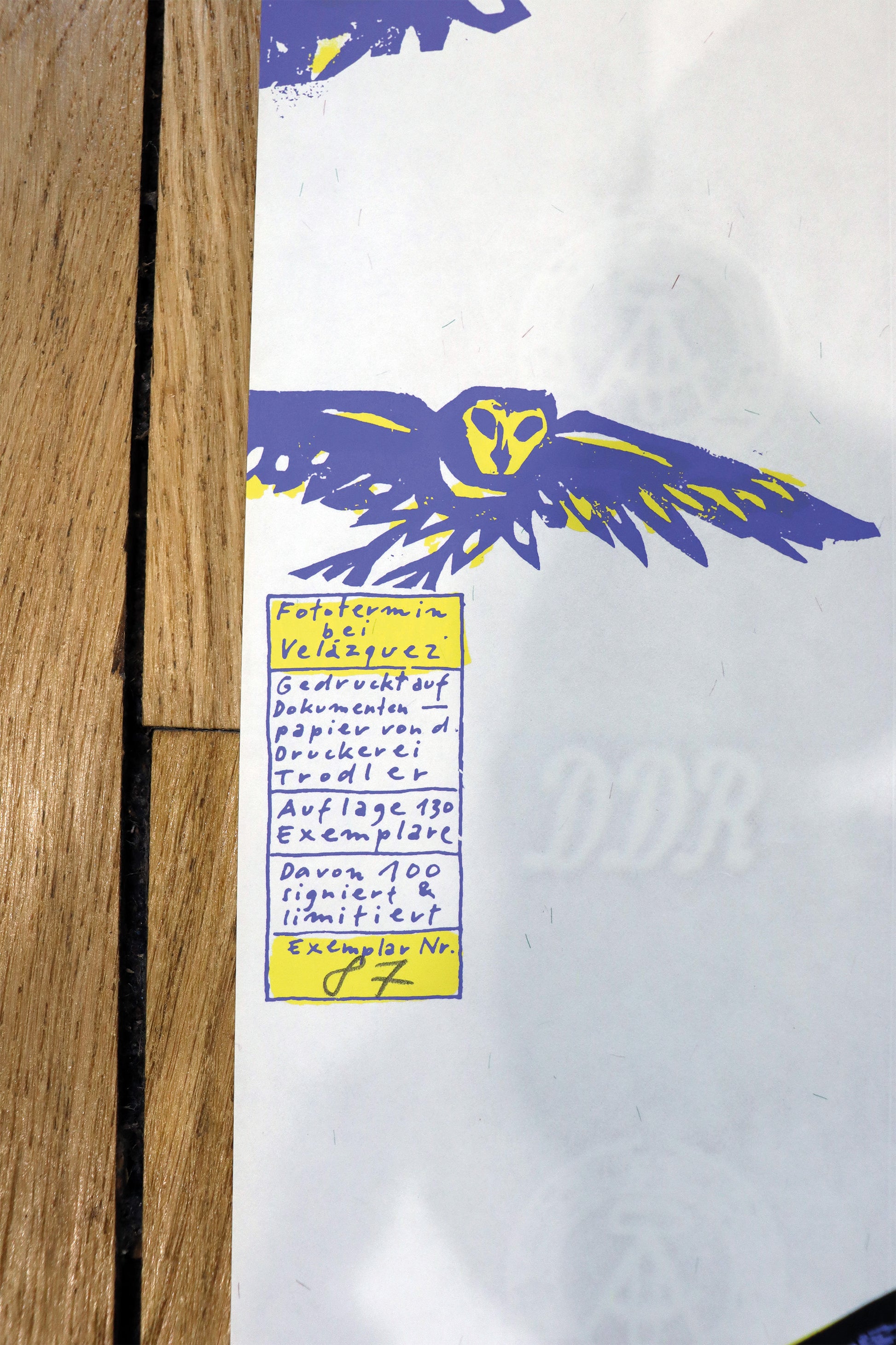 Druck Edition Trodler, von Wolf-Dieter Pfennig, Titel „Fototermin bei Velazques“ – Detailaufnahme der Vignette von Trodler und Exemplar-Nummer, in violett und gelb, Galerie Waldbach - What The Artist Made